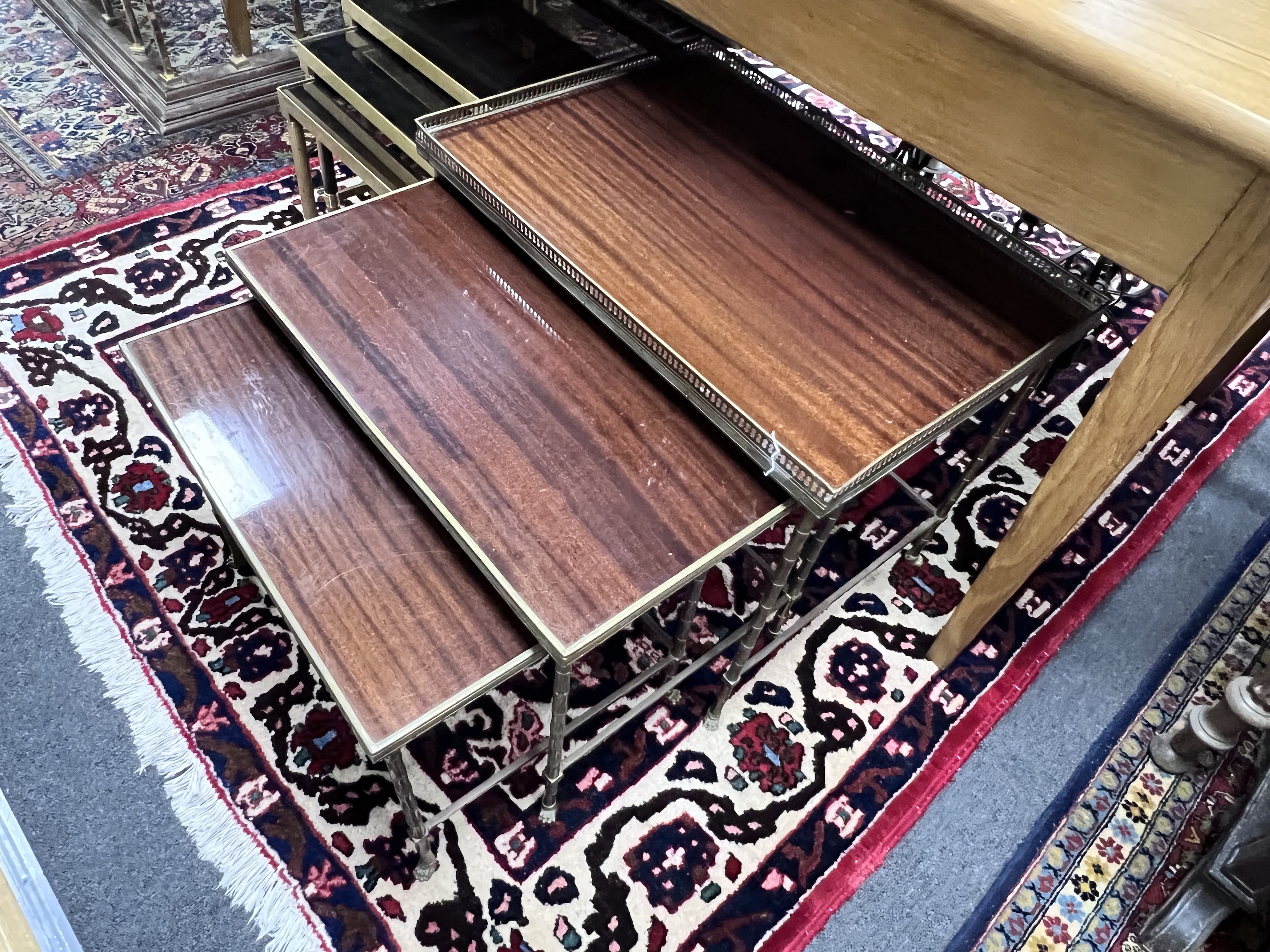 A nest of three graduated brass and mahogany faux bamboo 'Maison Charles' style tables, largest width 60cm